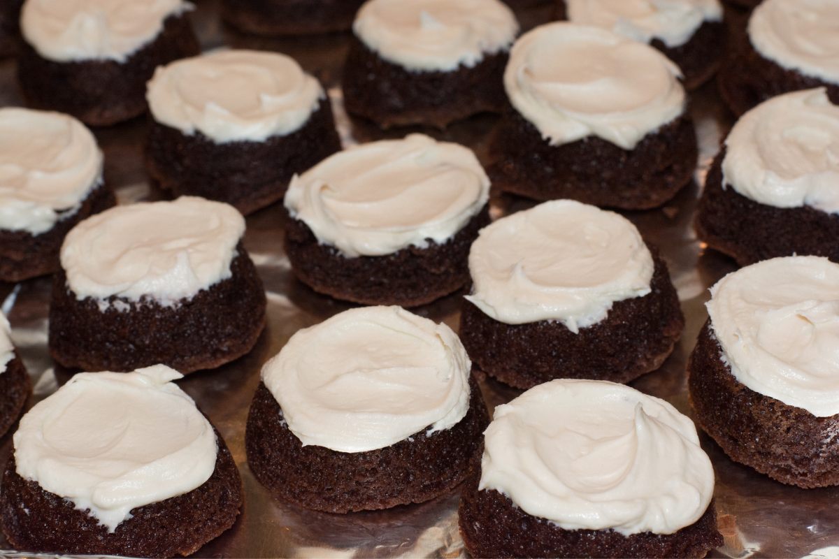Miniature frosted brownies with white frosting.