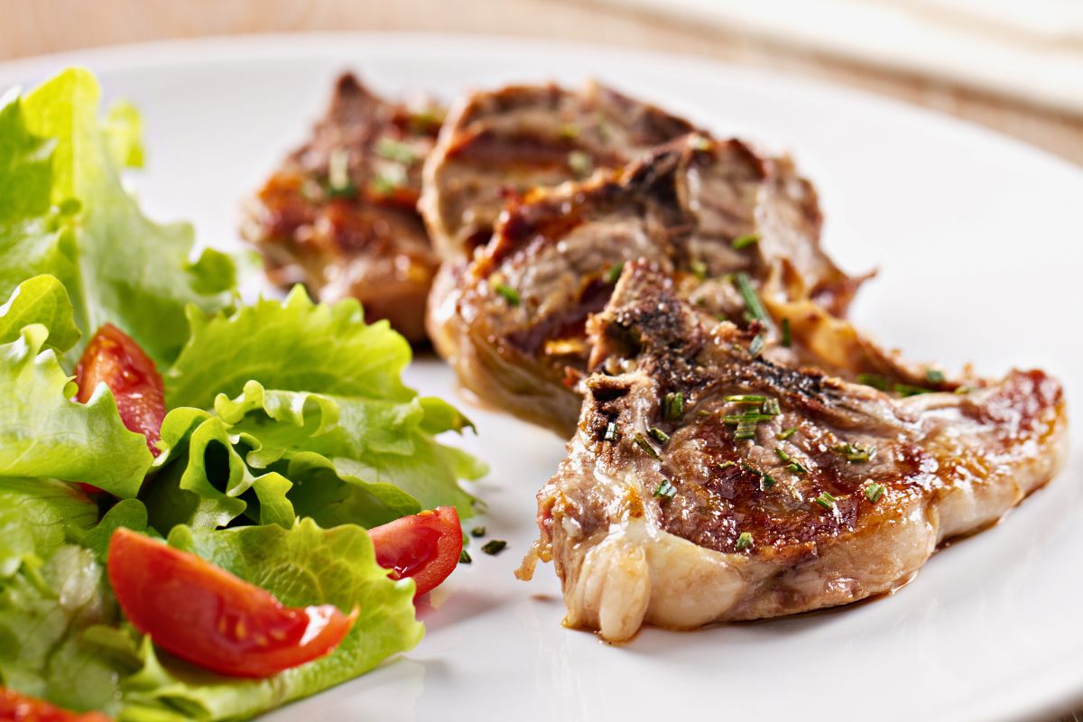 Grilled lamb chops in a plate with salad.