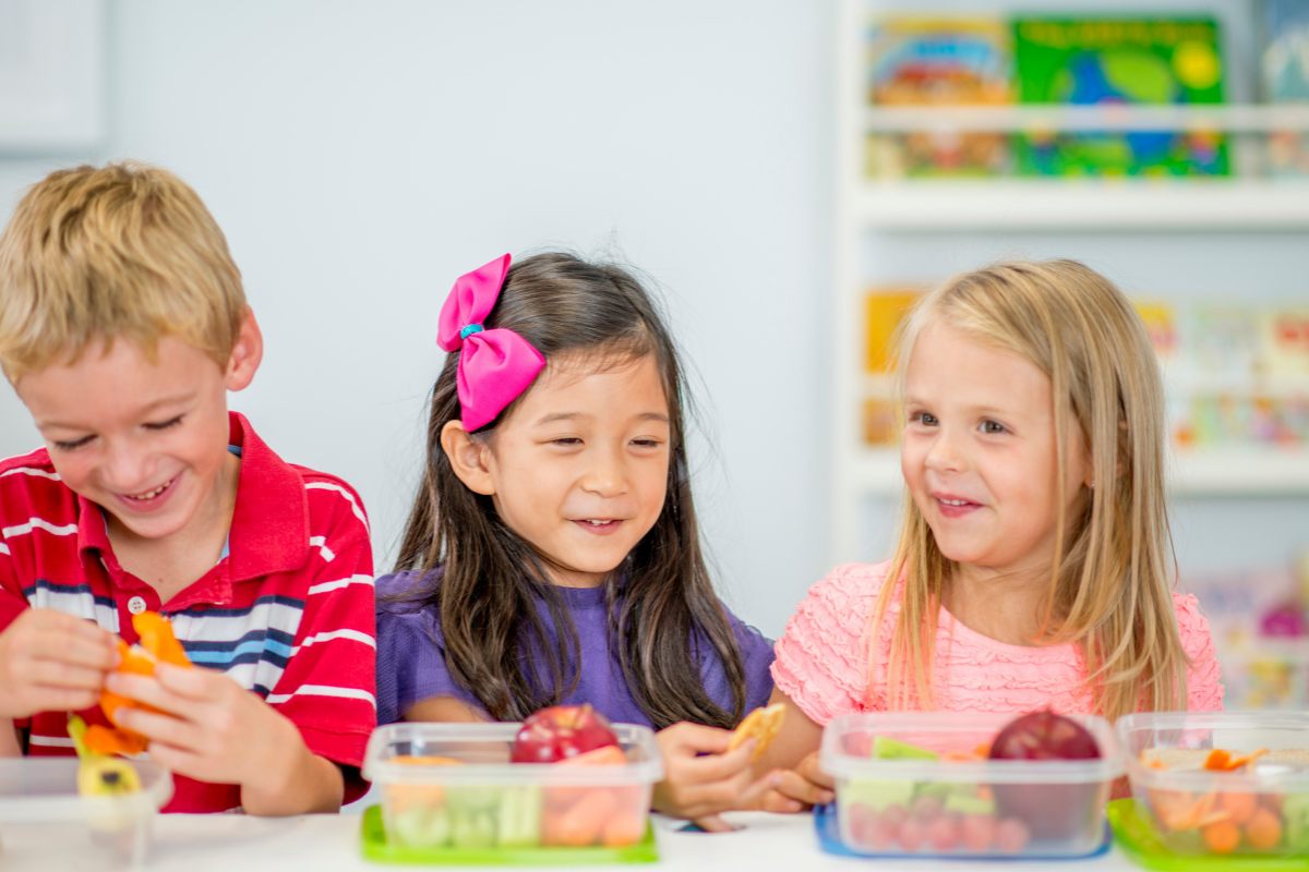 Kids esating healthy lunches at school.