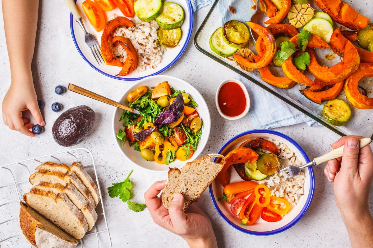 Hands of a family grabbing vegetarian food.