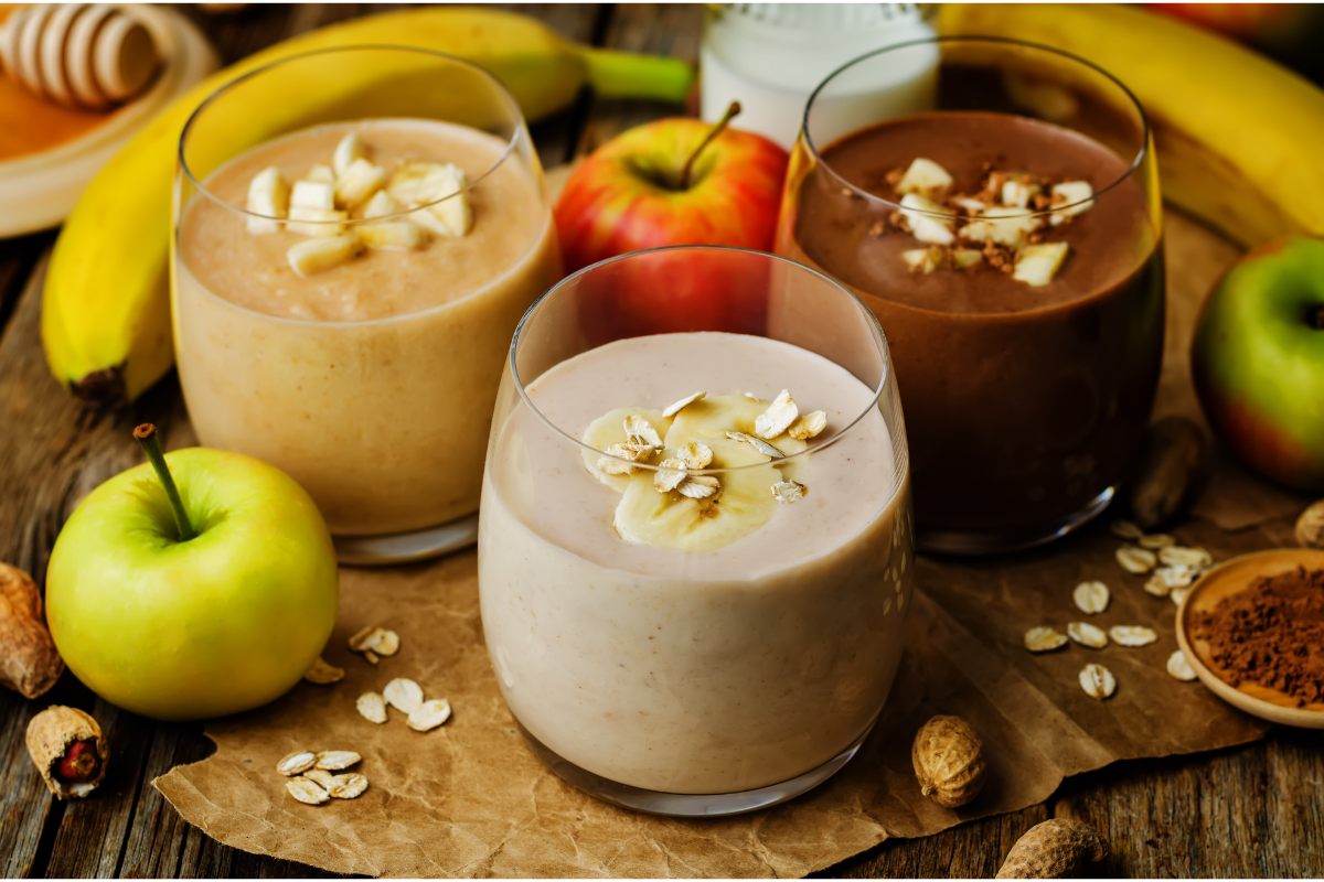 Three glasses of chocolate nut butter smoothie with different amounts of cocoa powder.