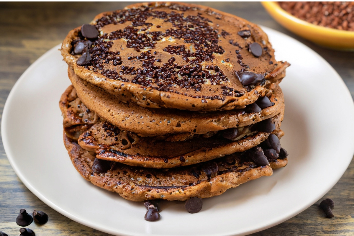 A pile of quinoa and chocolate chip pancakes on a plate.