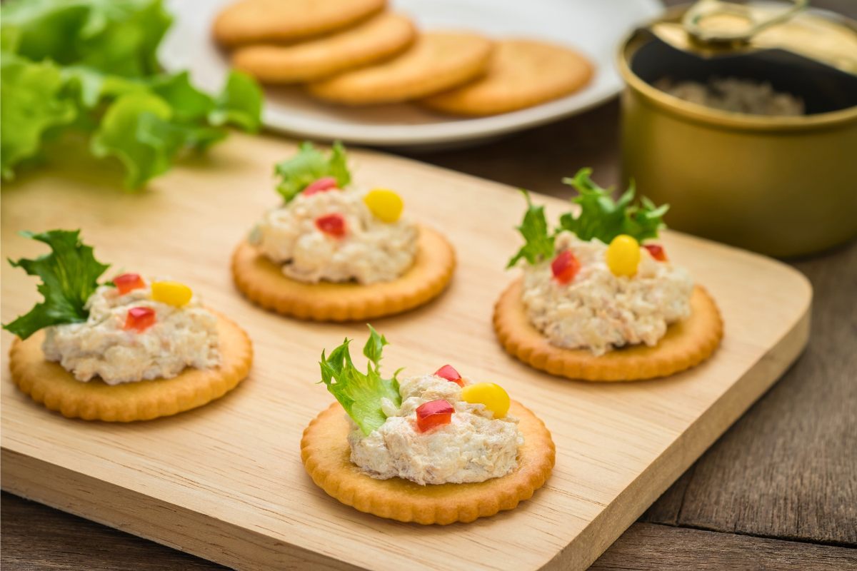 Preparing tuna paté on crackers.