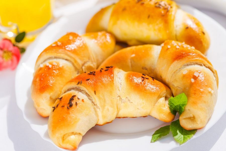Four homemade stuffed crescent rolls on a plate.